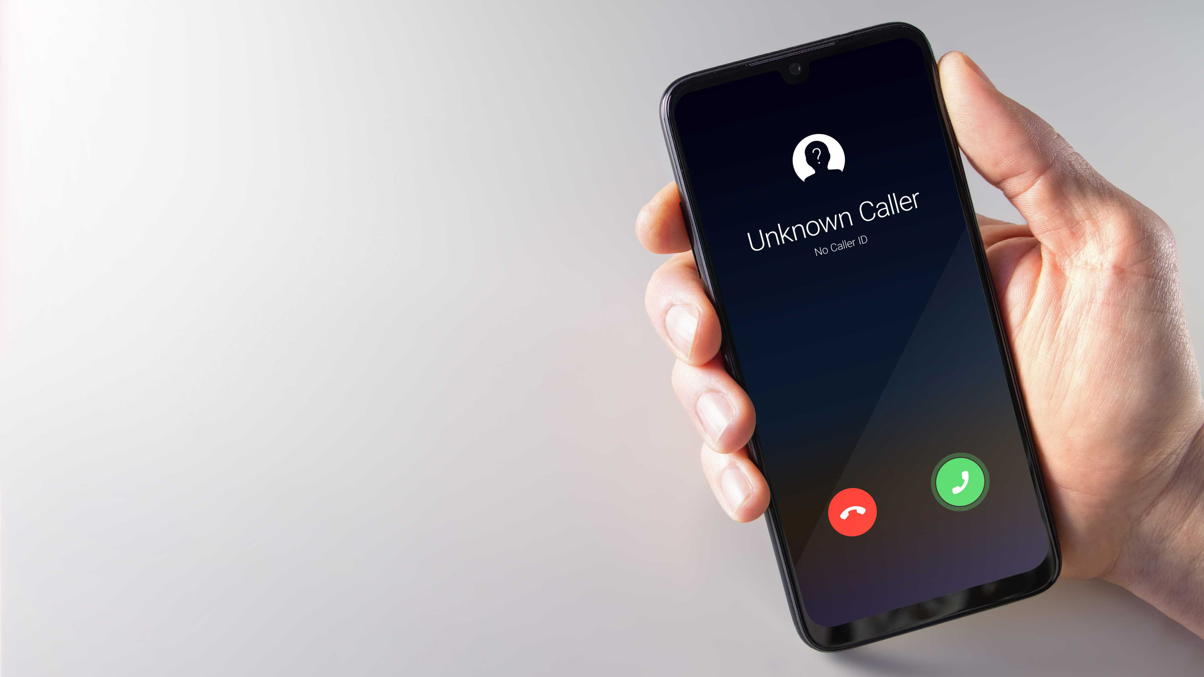 Main masculine tenant un smartphone avec un appelant inconnu affiché à l'écran