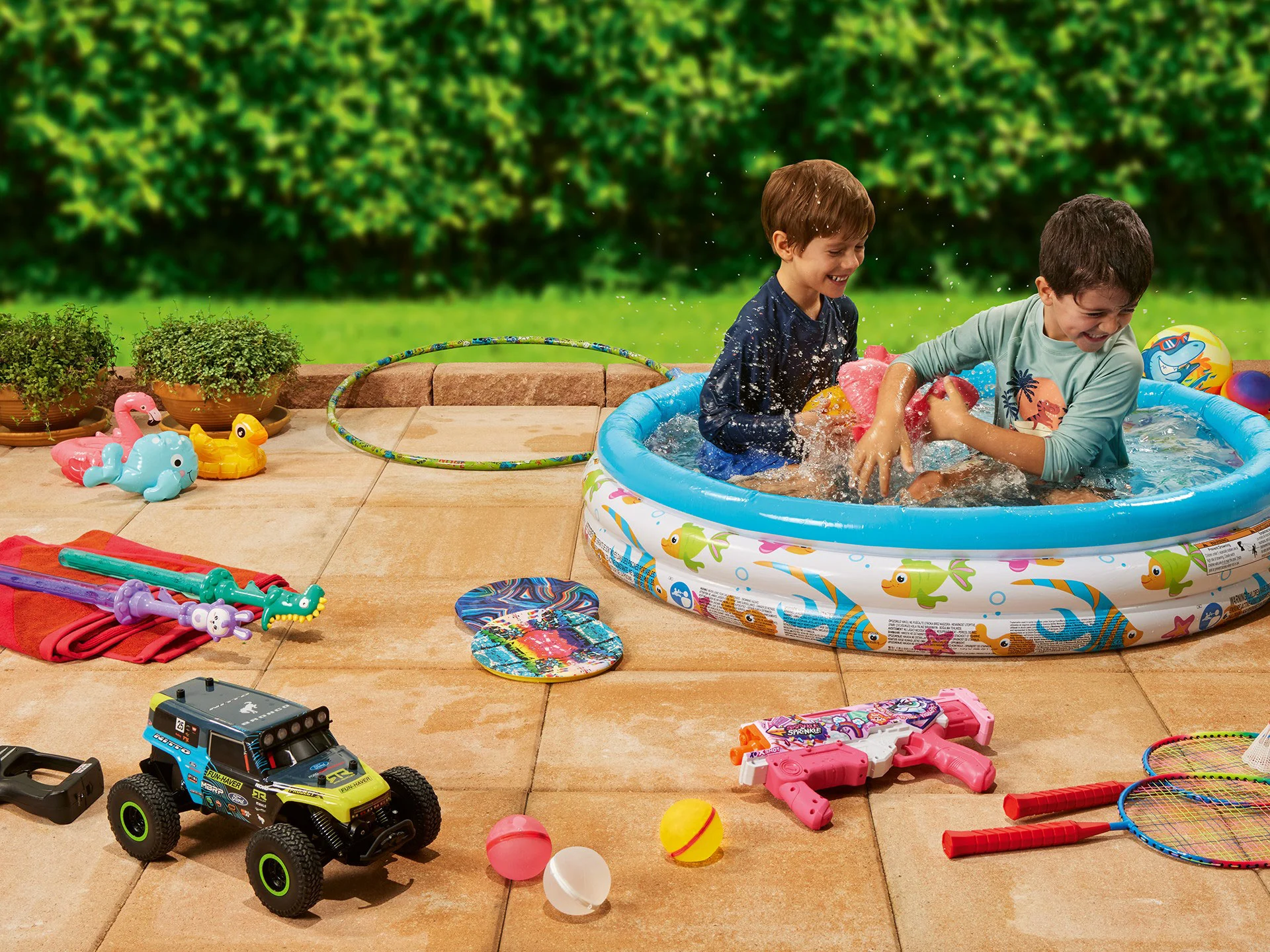 Two boys playing in a paddling pool