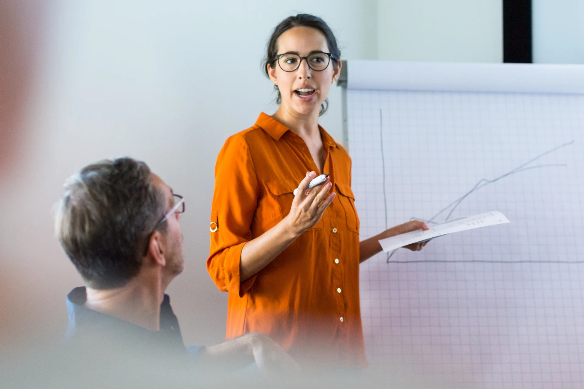 Businesswoman giving presentation to colleagues in conference room.