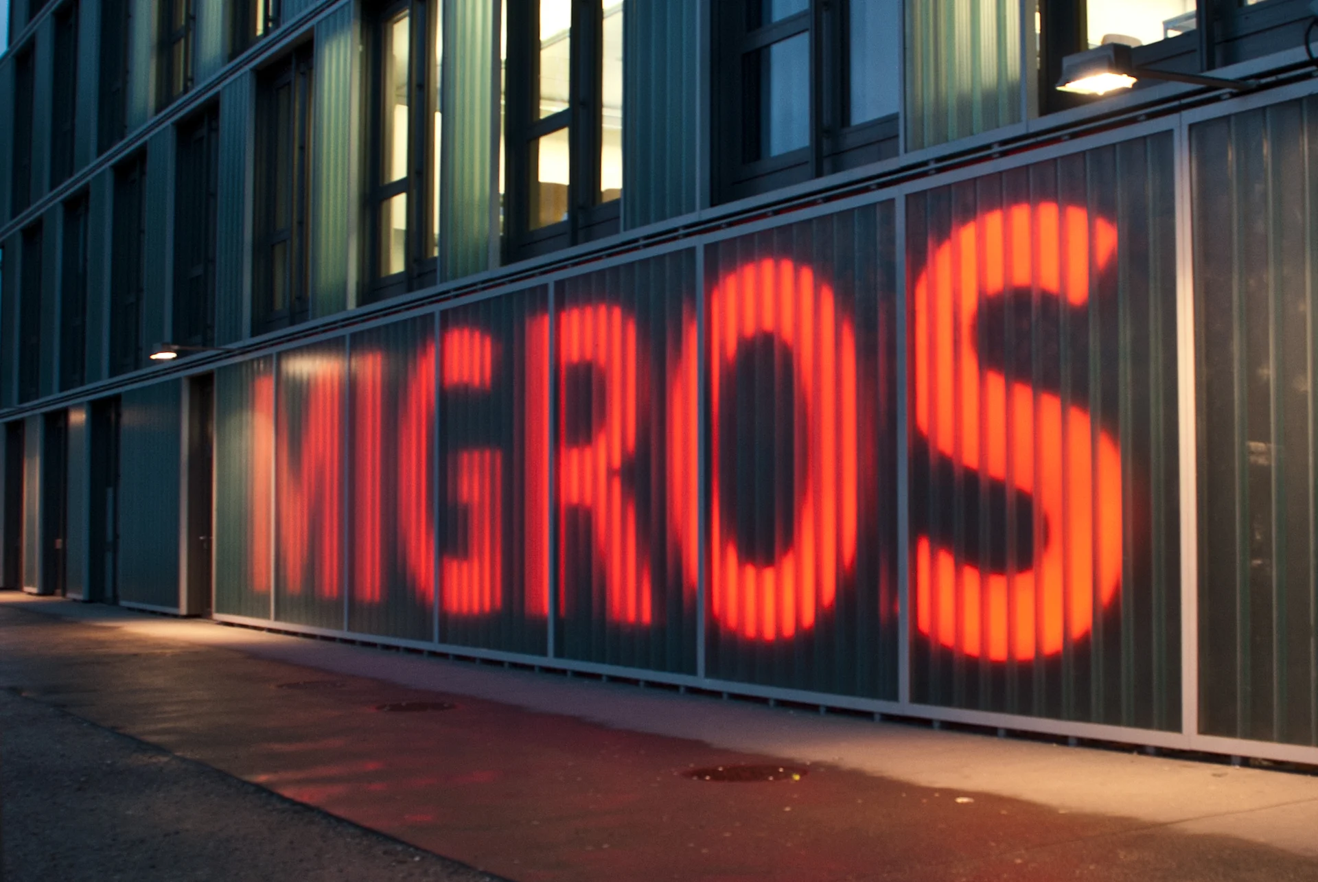 Inscription Migros sur un mur de bâtiment