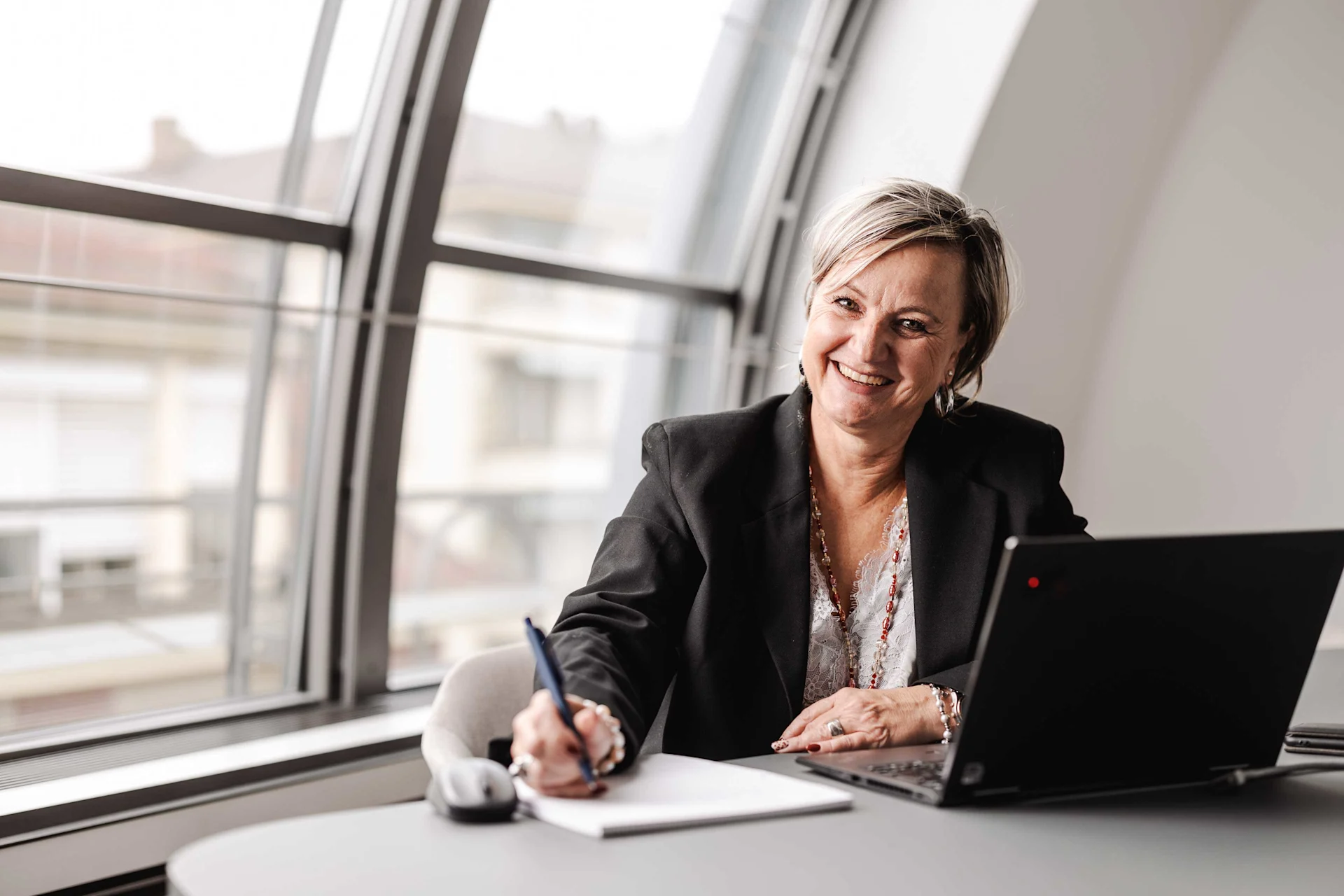 Nancy Gaudin sitzt an einem Schreibtisch in einem Büro