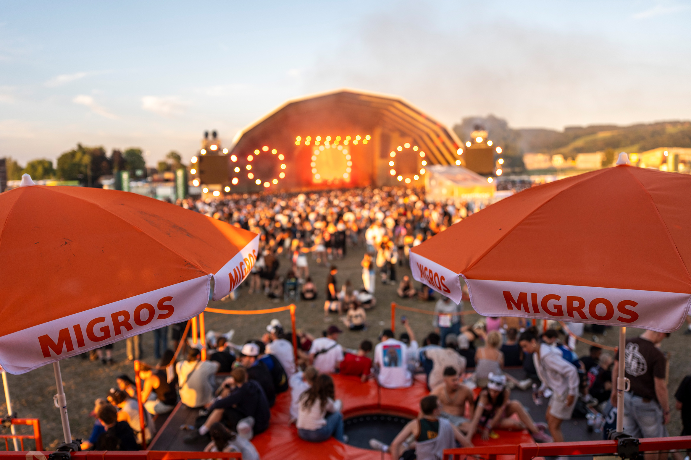 Evening atmosphere on the festival grounds around the Migros stand.
