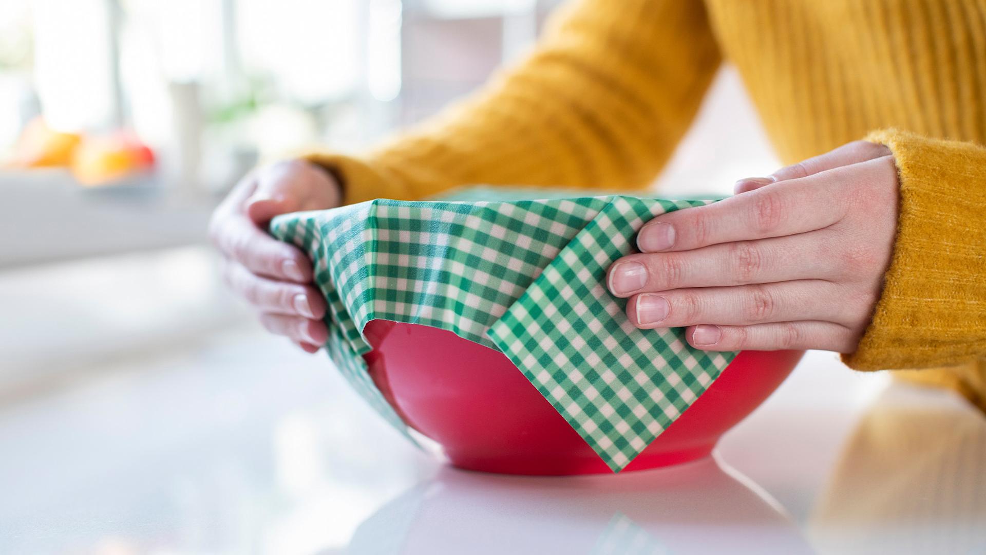 A woman holds a bowl covered with a beeswax cloth