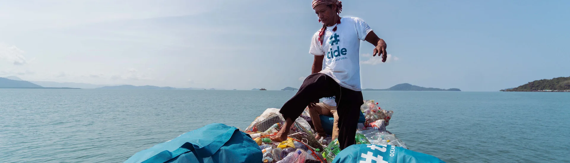Mann sammelt Kunststoffabfälle vom Meer