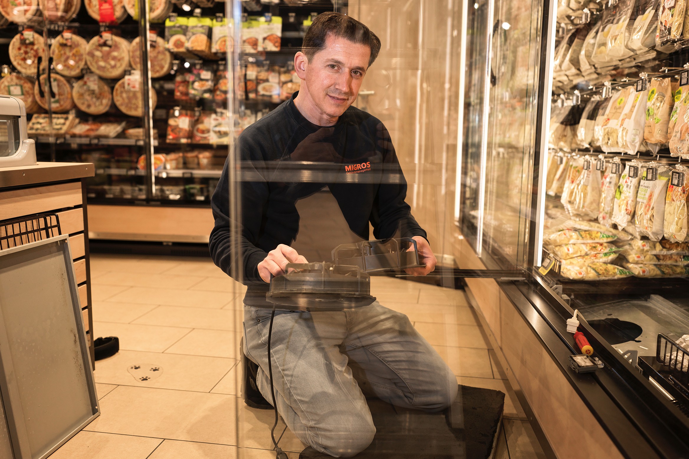 Samidin Badalli, technicien frigoriste à Migros, travaillant sur un appareil frigorifique.