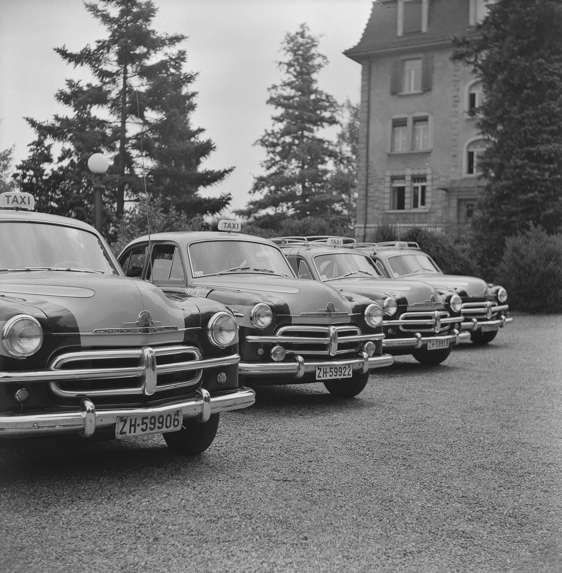 A black-and-white photograph of four taxis owned by Duttweiler