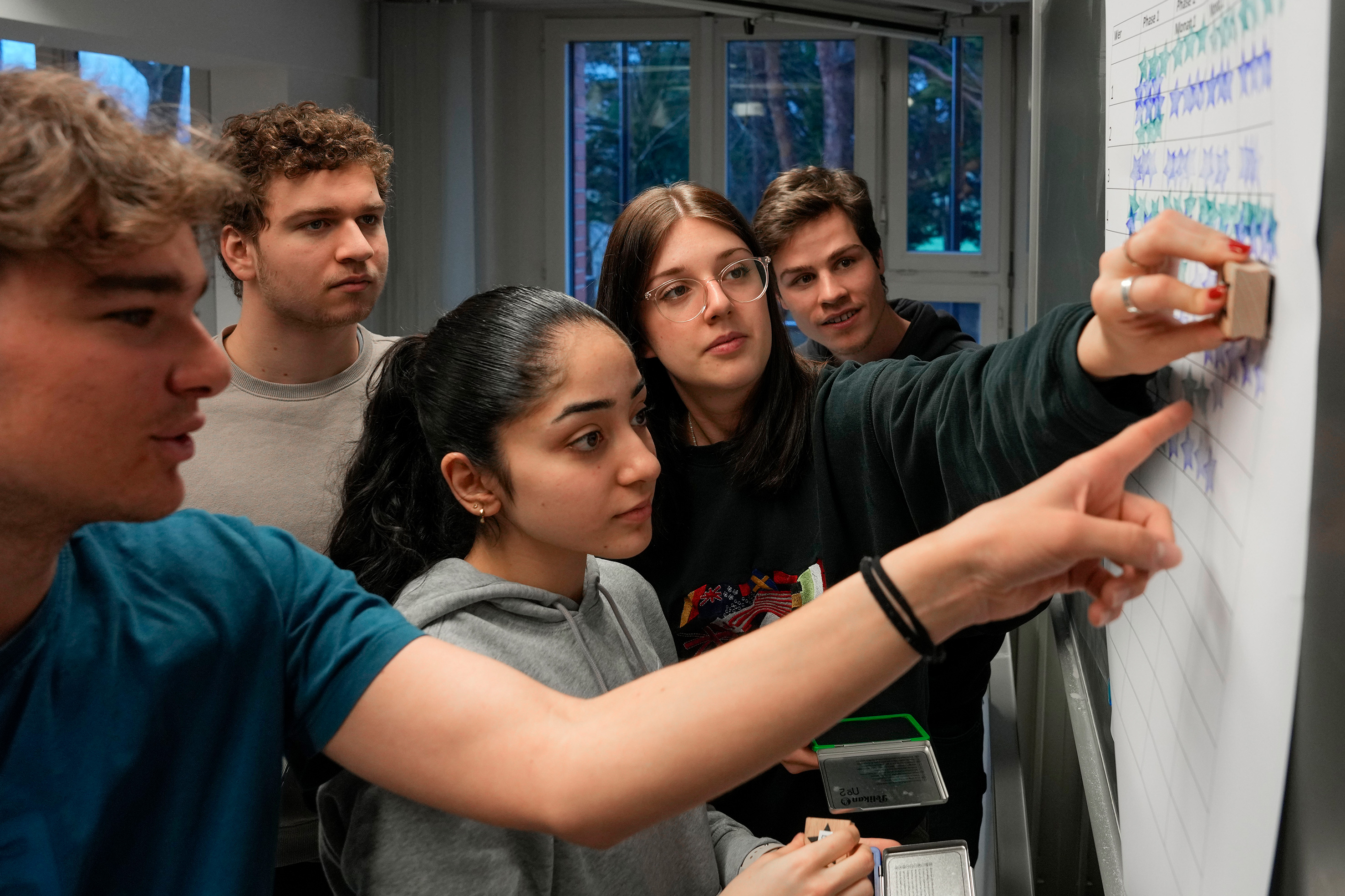 Flavio, Leander, Esra, Michelle and Michel record their star balance by stamping it on a poster.