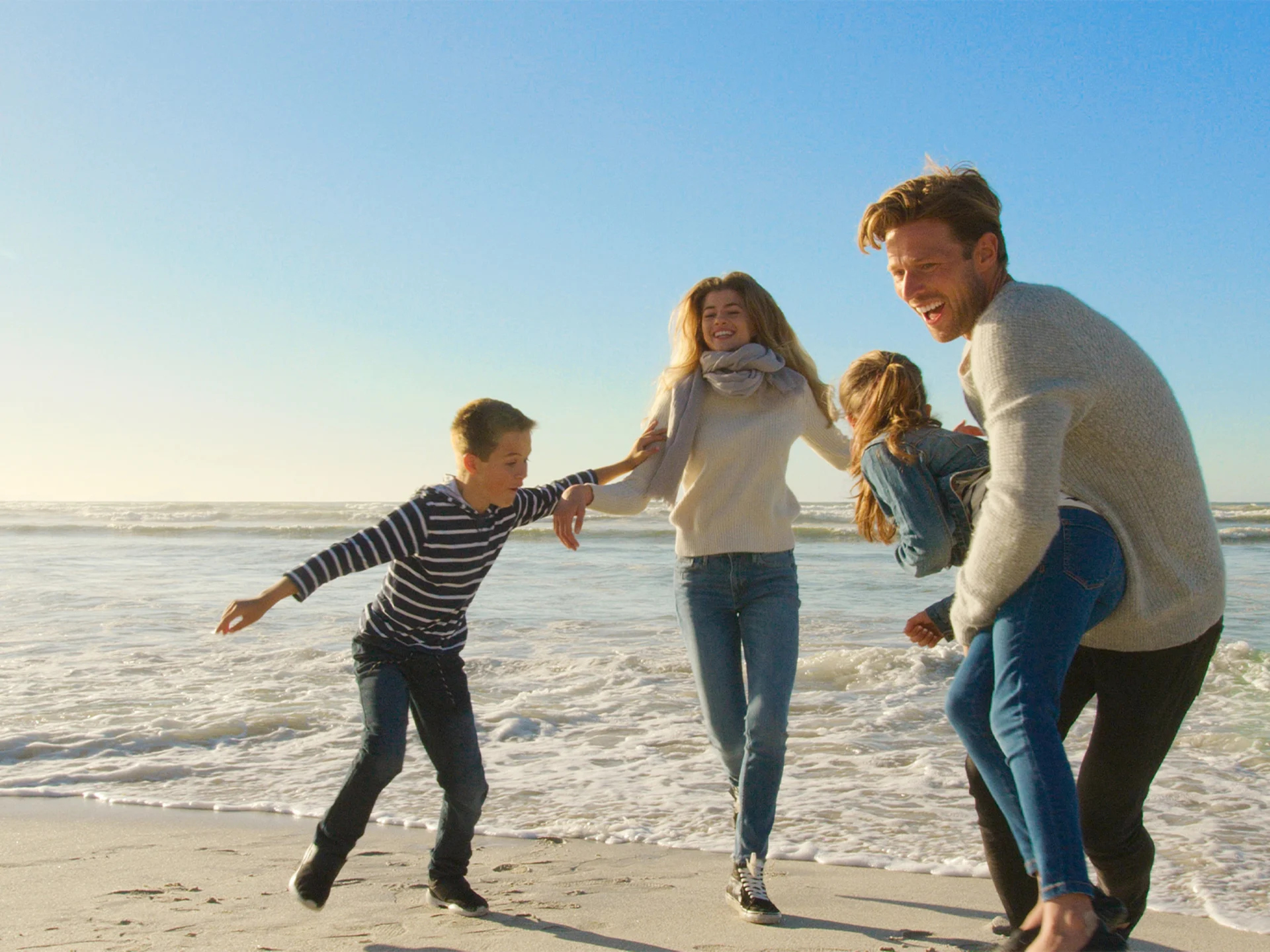 Eine Familie läuft den Strand entlang