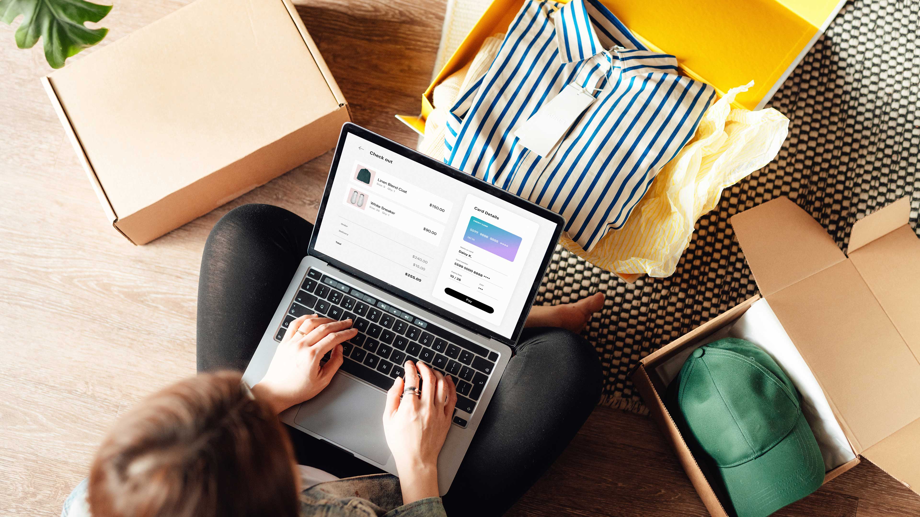 Una persona si siede sul pavimento ed effettua un ordine online su un computer portatile.