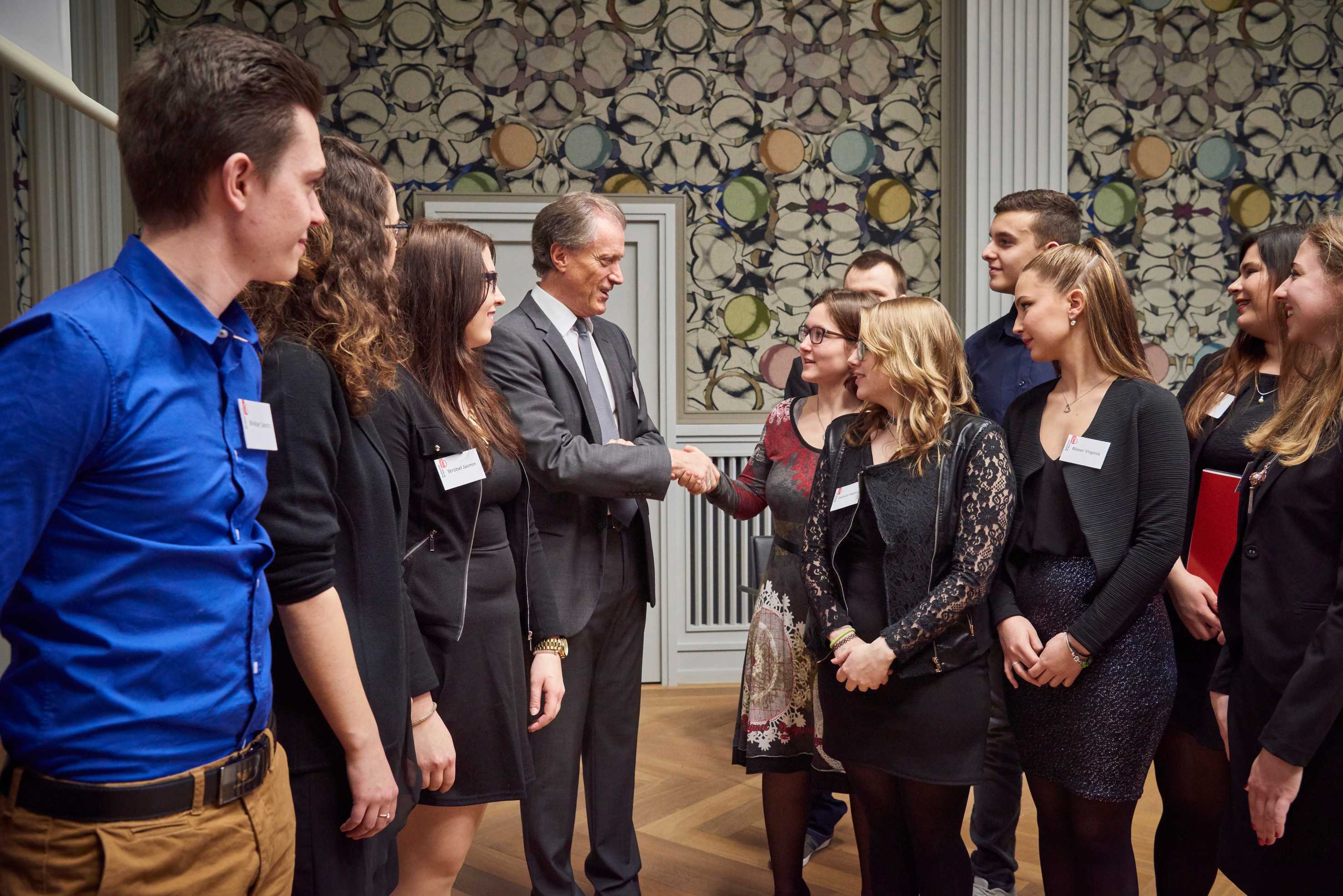 Herbert Bolliger et une apprentie se serrent la main.