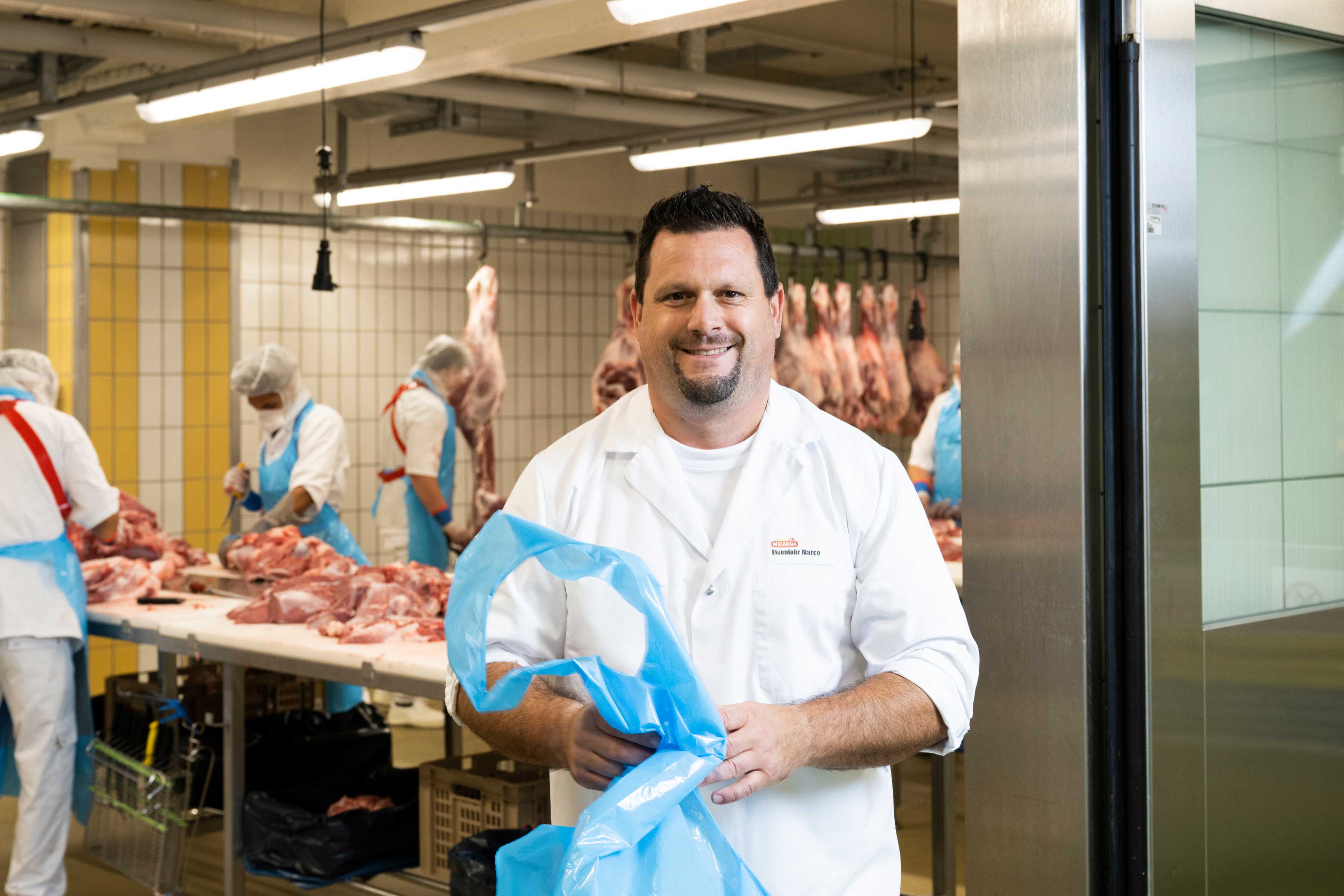 Marco Eisenlohr se tient devant un hall où est transformée la viande