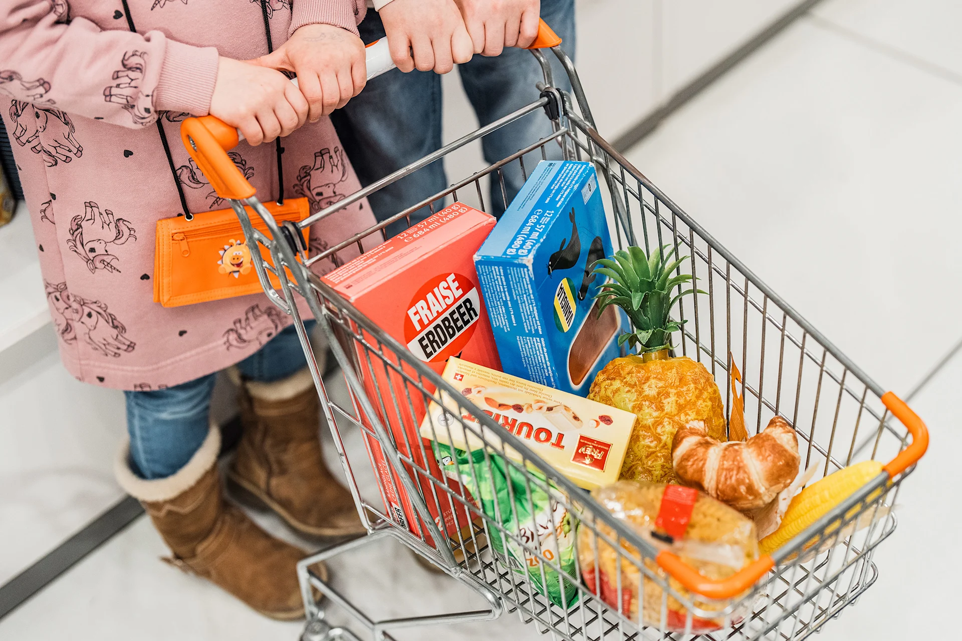 Einkaufswagen der Mini-Migros gefüllt mit Produkten in Minigrösse