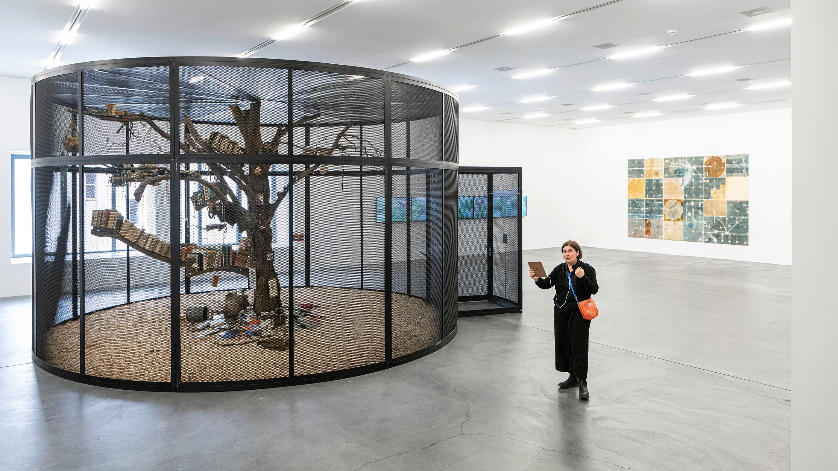 Eine Frau steht im Migros Museum und hält ein iPad in der Hand