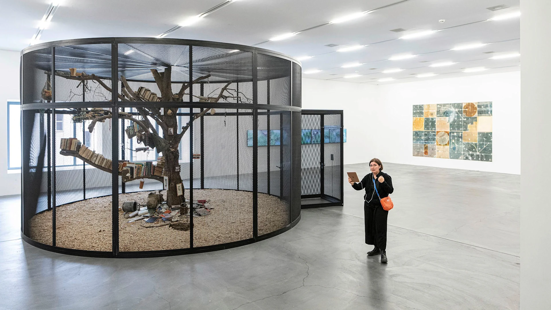 A woman stands in the Migros Museum and holds an iPad in her hand