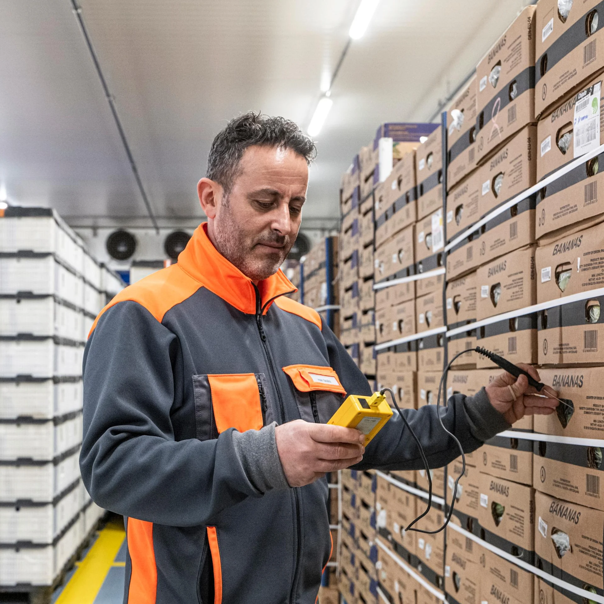  A worker checks a package using an electronic device.