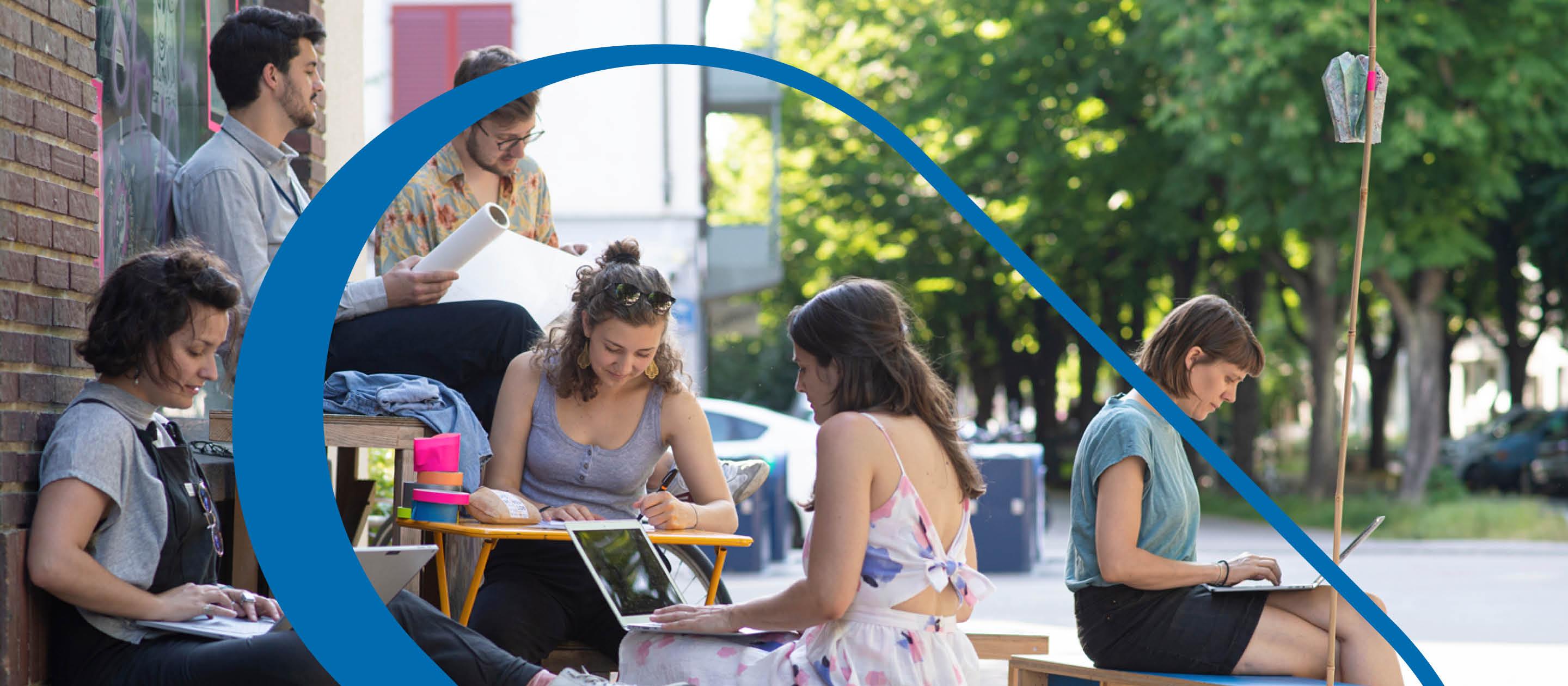 Diverses personnes sont assises dehors et travaillent sur leurs ordinateurs portables