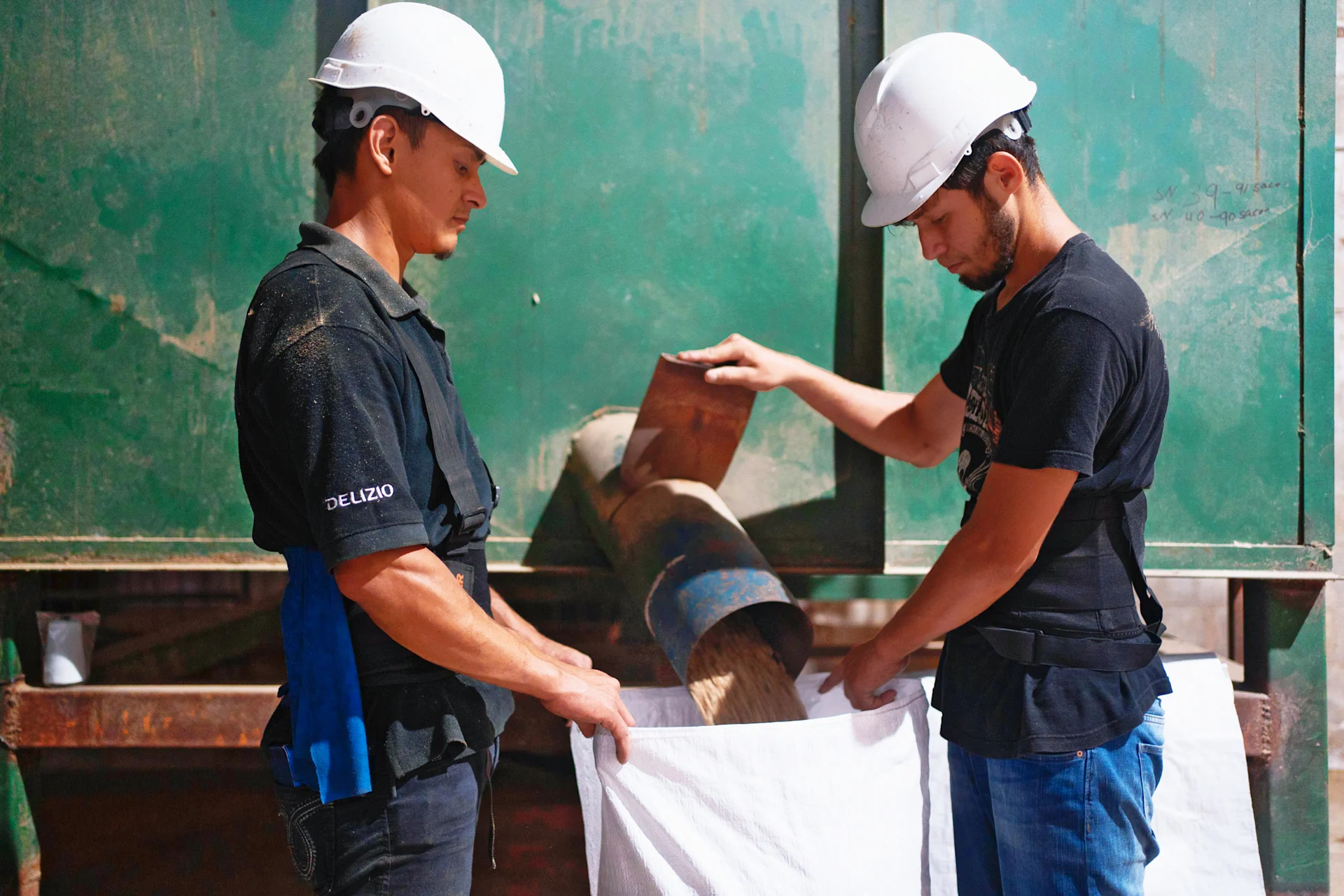 Two construction workers, one with a Delizio shirt.