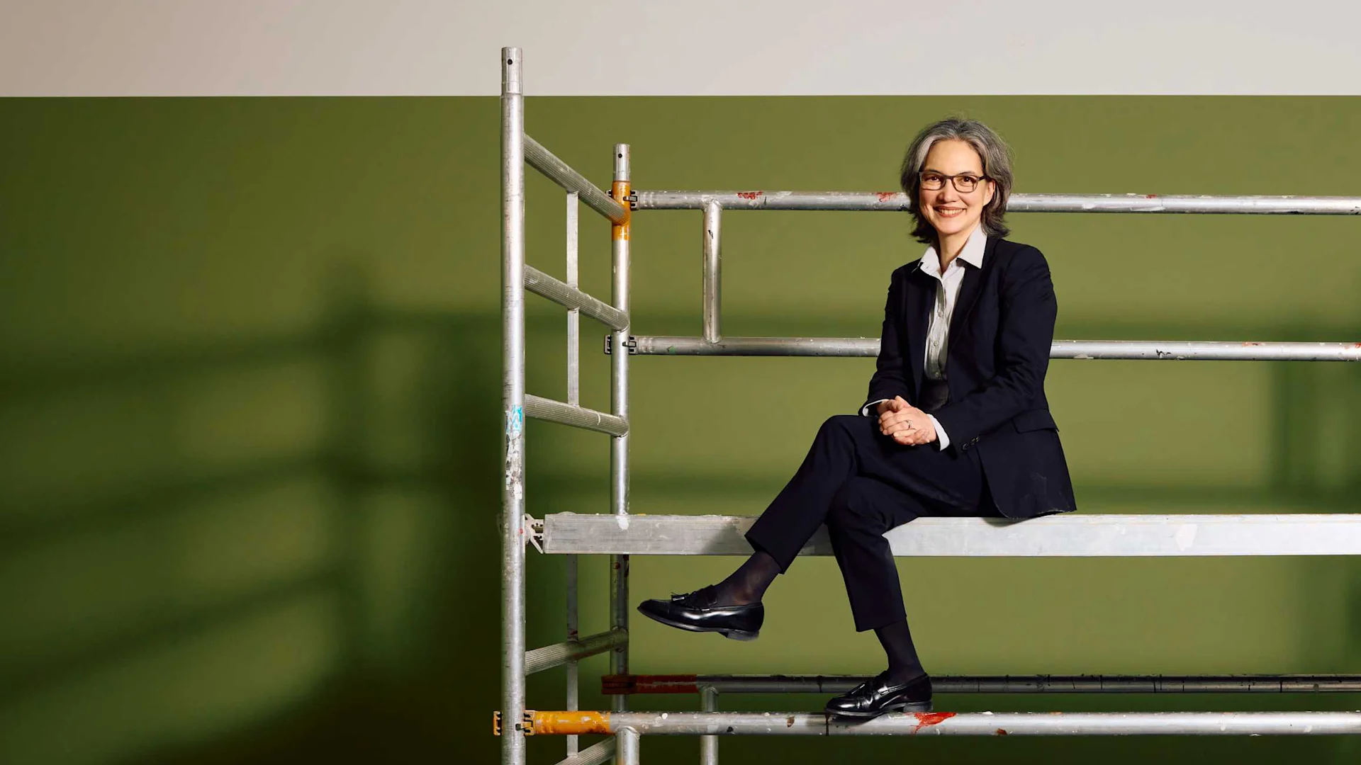 Mira Song, Leiterin Gesellschaft und Kultur Migros, sitzt auf einer Leiter