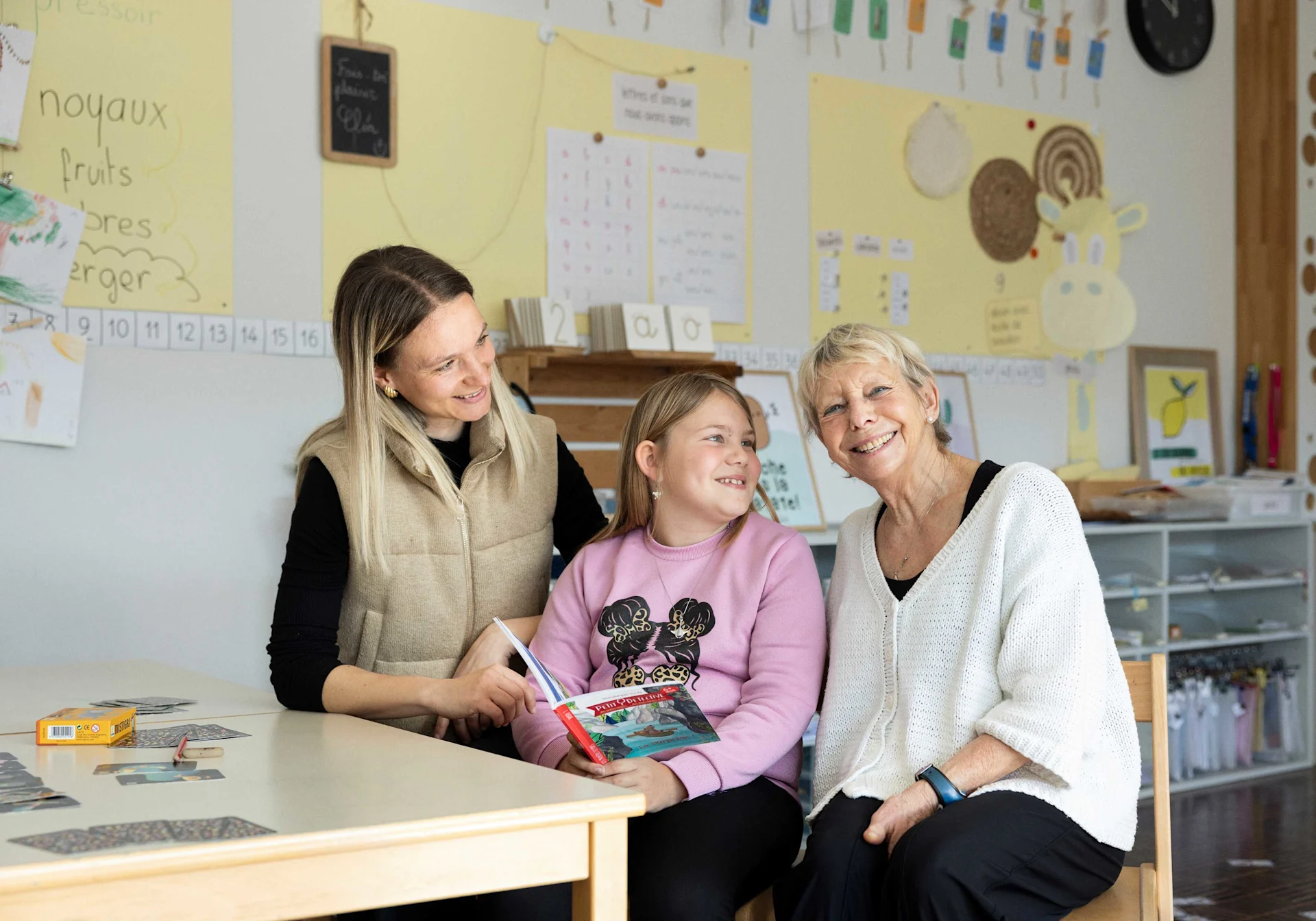 Anne-Françoise Droz im Schulzimmer zusammen mit Lehrerin Marie Negri und Schülerin Finja Riedwyl.