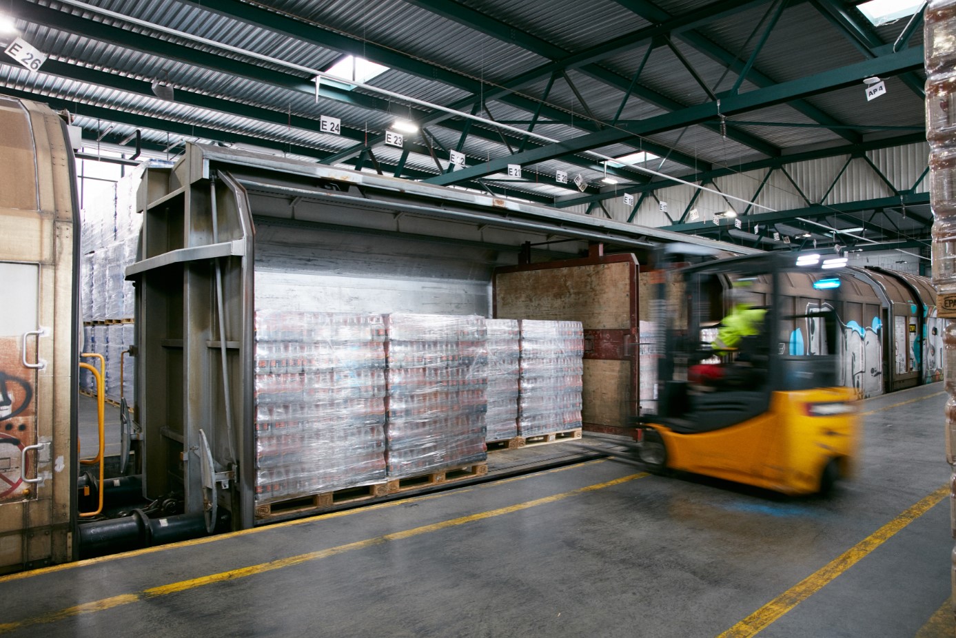 A forklift stacks Aproz mineral water bottles.