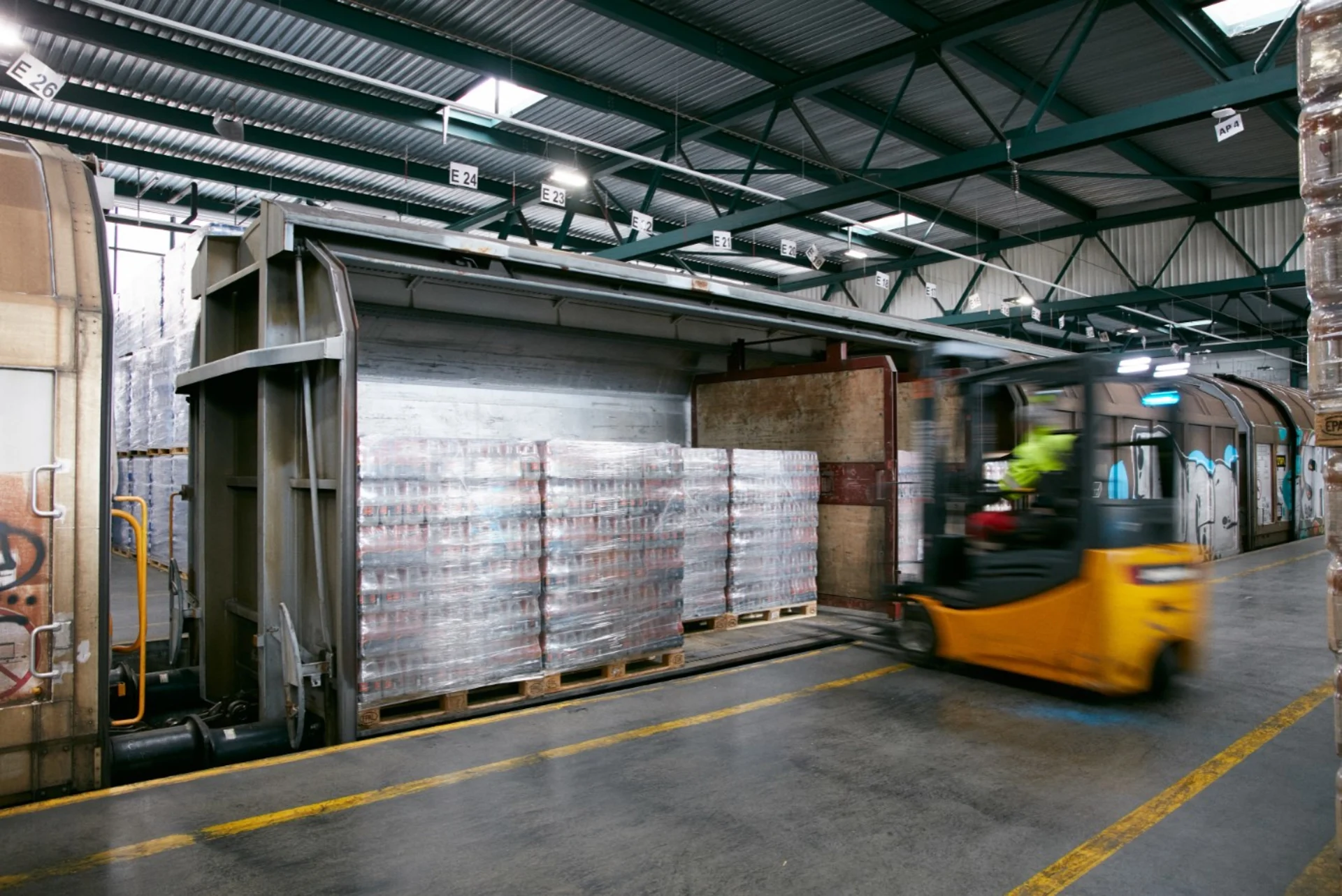 A forklift stacks Aproz mineral water bottles.