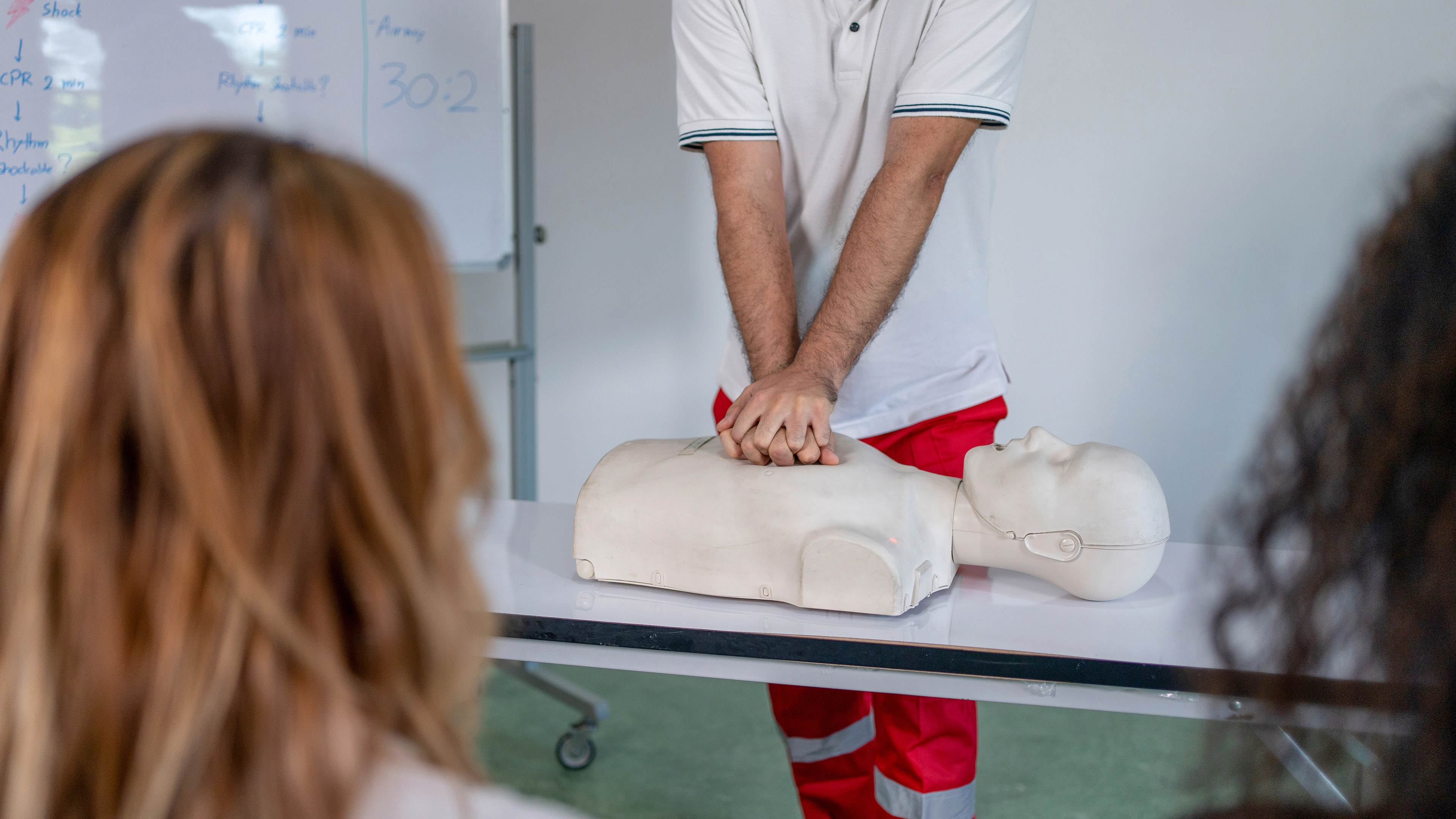 Un paramedico dimostra la rianimazione cardiopolmonare durante un corso di pronto soccorso.