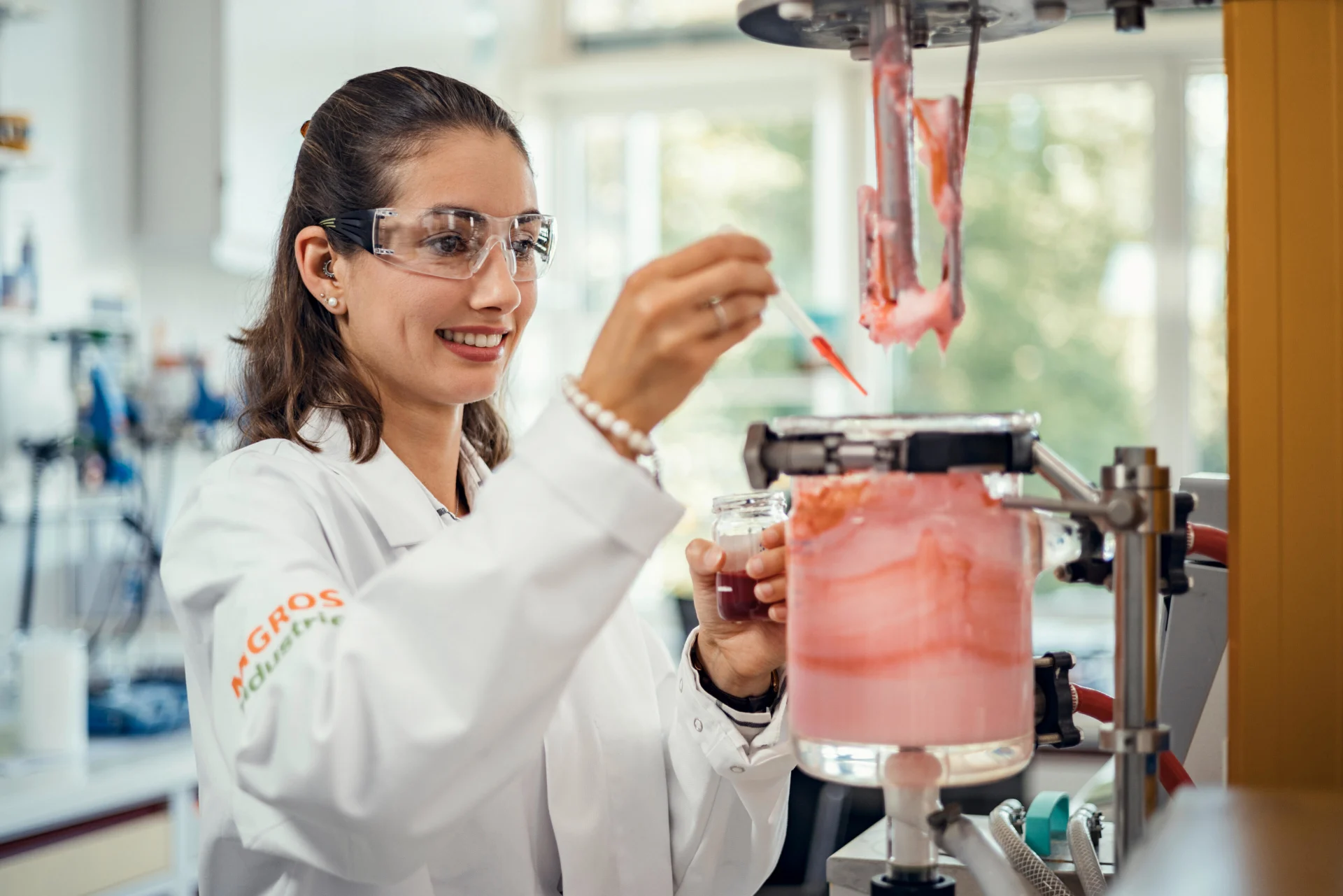 Eine Mitarbeiterin fügt im Labor Farbstoff in eine Kosmetikcreme