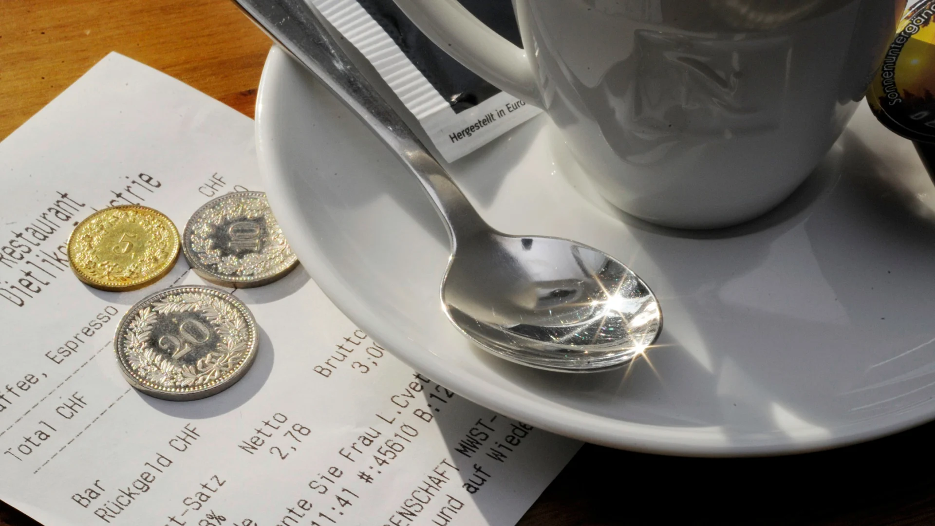 An espresso and the receipt with a tip on a table