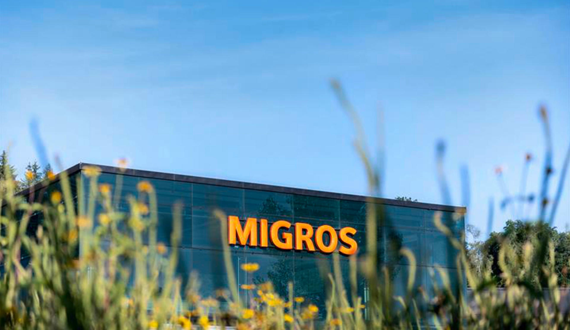 A modern building with the Migros logo