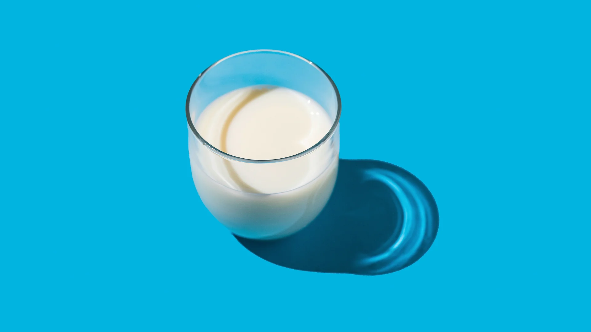 A glass of milk on a light blue background