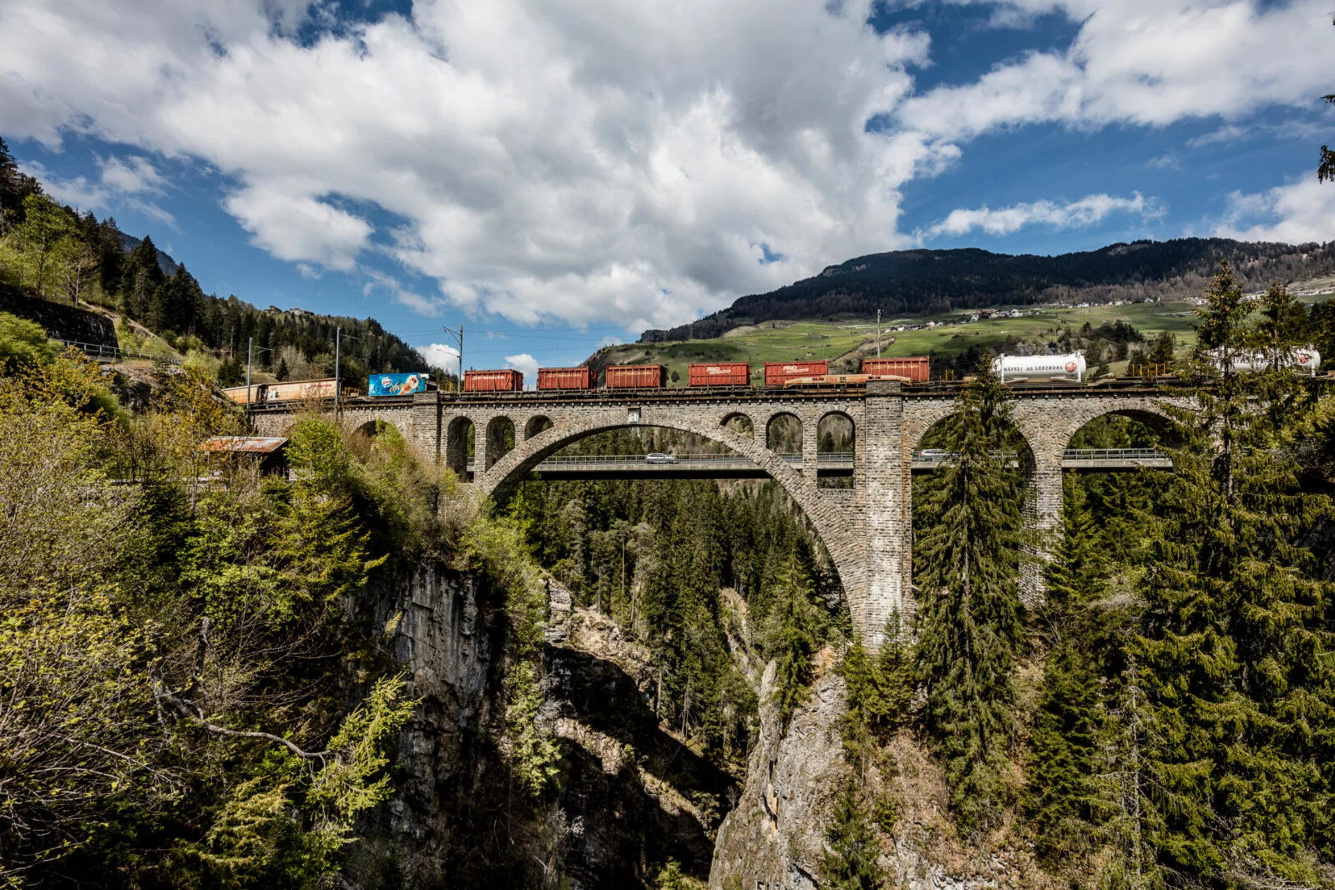 The Rhaetian Railway travels over a viaduct in an idyllic setting