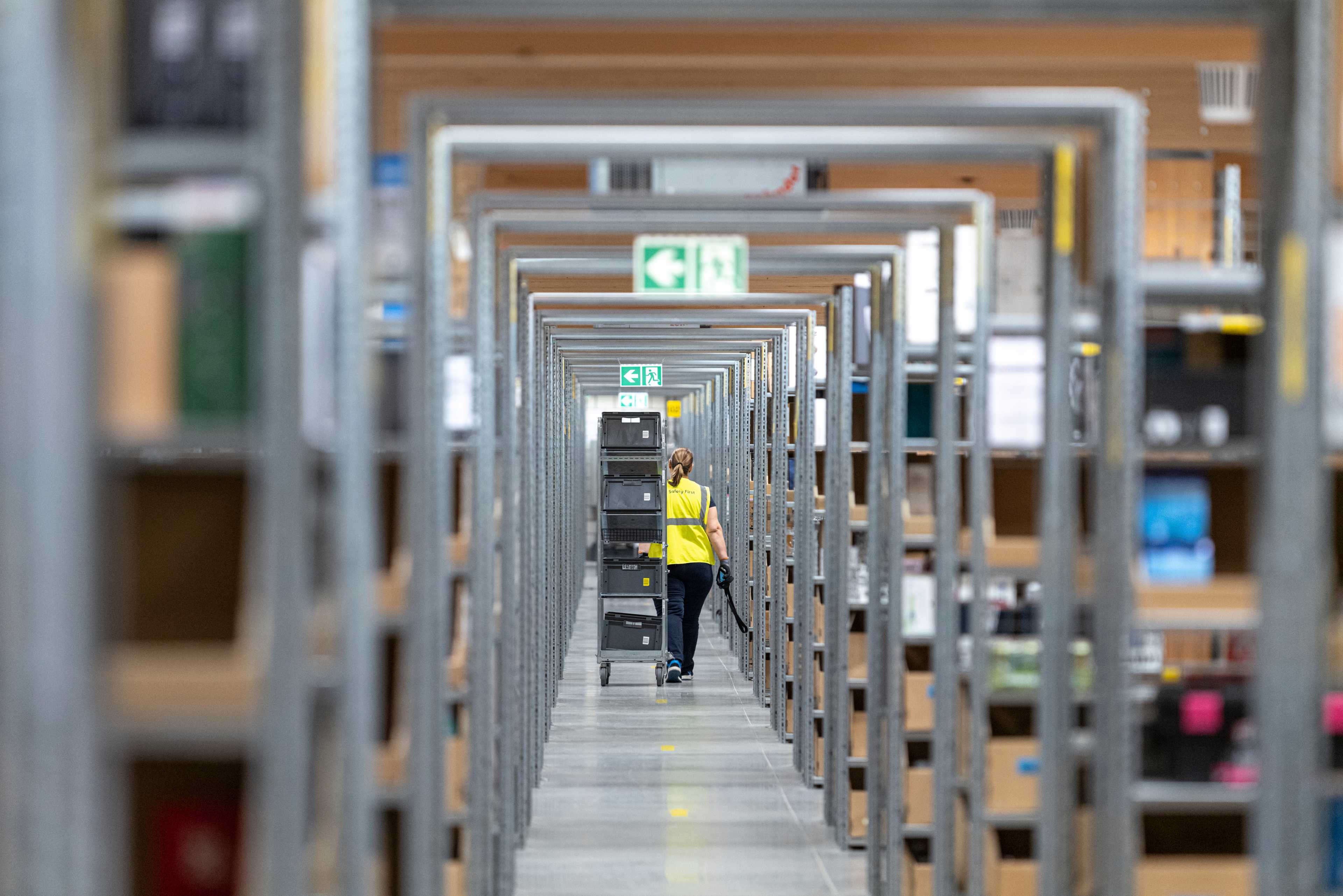 Un lungo corridoio con molti scaffali a destra e a sinistra.