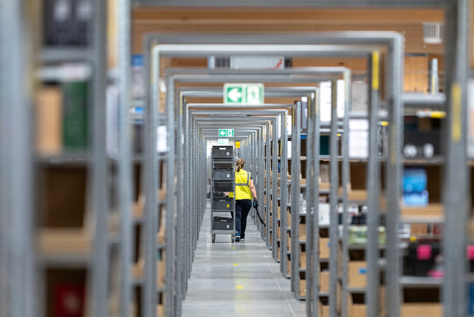 Un lungo corridoio con molti scaffali a destra e a sinistra.