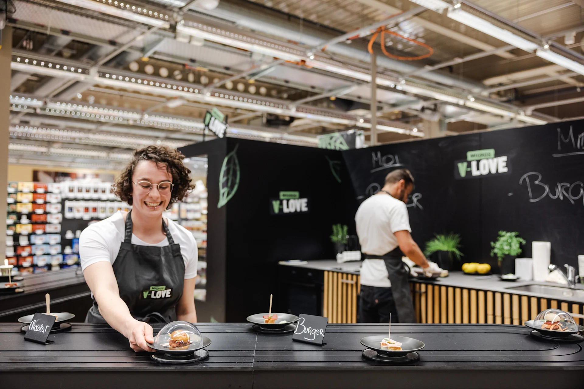 Une employée à un stand V-Love dans un magasin.