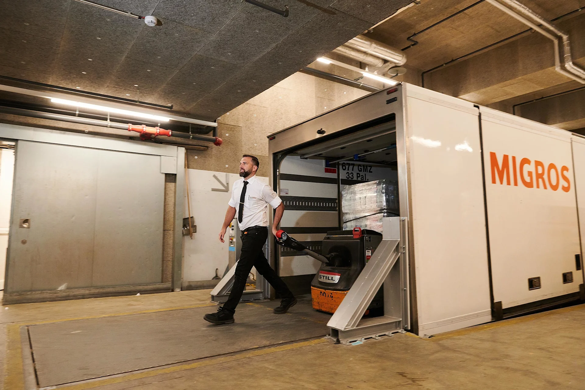 Yves Brunner aide à transporter des marchandises du camion jusque dans le magasin.