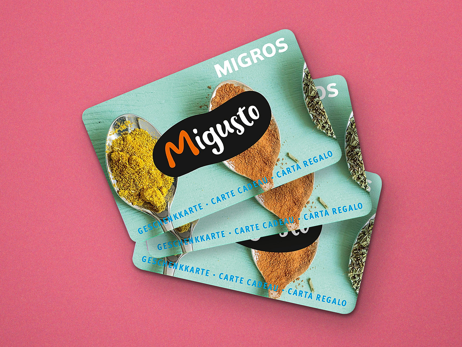 Migros Geschenkkarte mit Migusto Motiv auf hellrotem Hintergrund