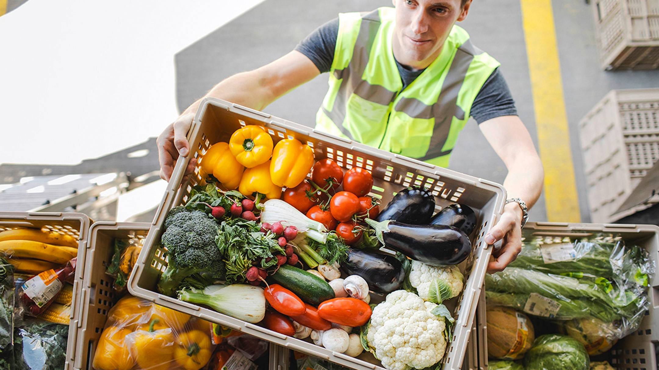 A man takes a box of vegetables