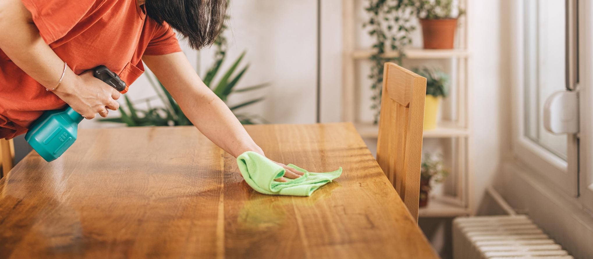 Person reinigt Tisch