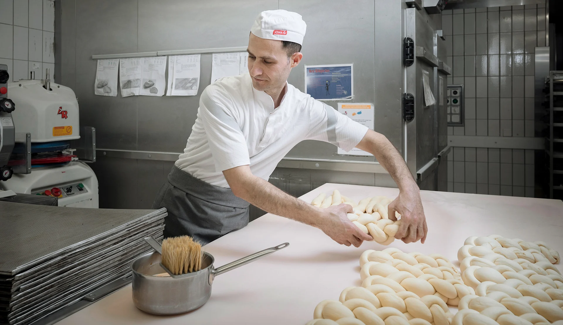 Dans la boulangerie bernoise, Fuad Asaad tresse la pâte. Dans la boulangerie bernoise, Fuad Asaad tresse la pâte.