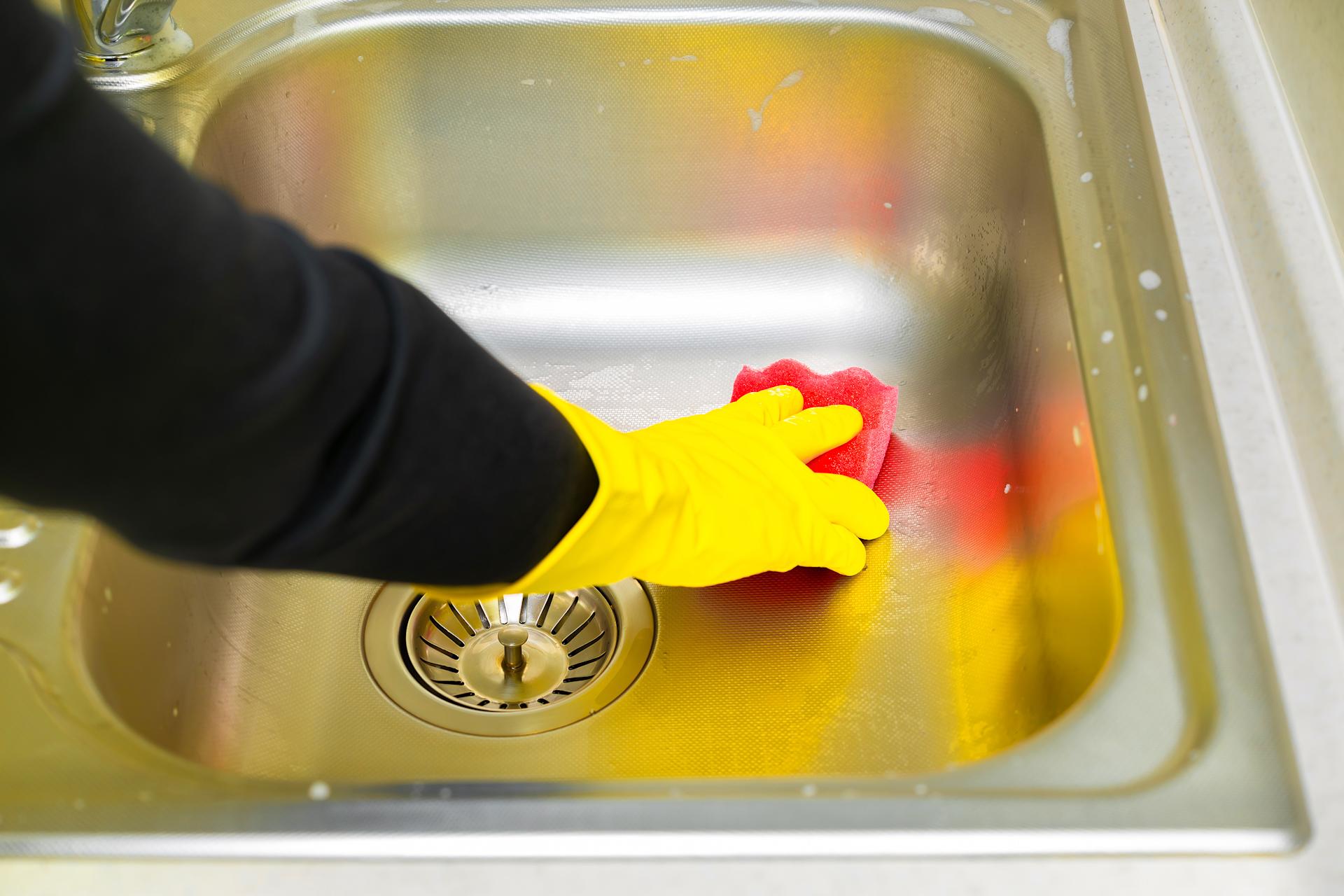 Ein Lavabo wird mit einem Putzlappen gereinigt
