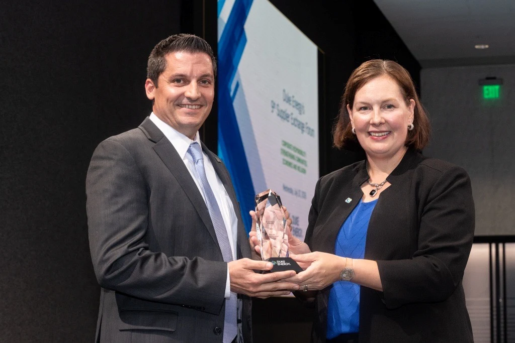 Black & Veatch CFO Michael Williams receives award from Duke Energy's Katie Aittola