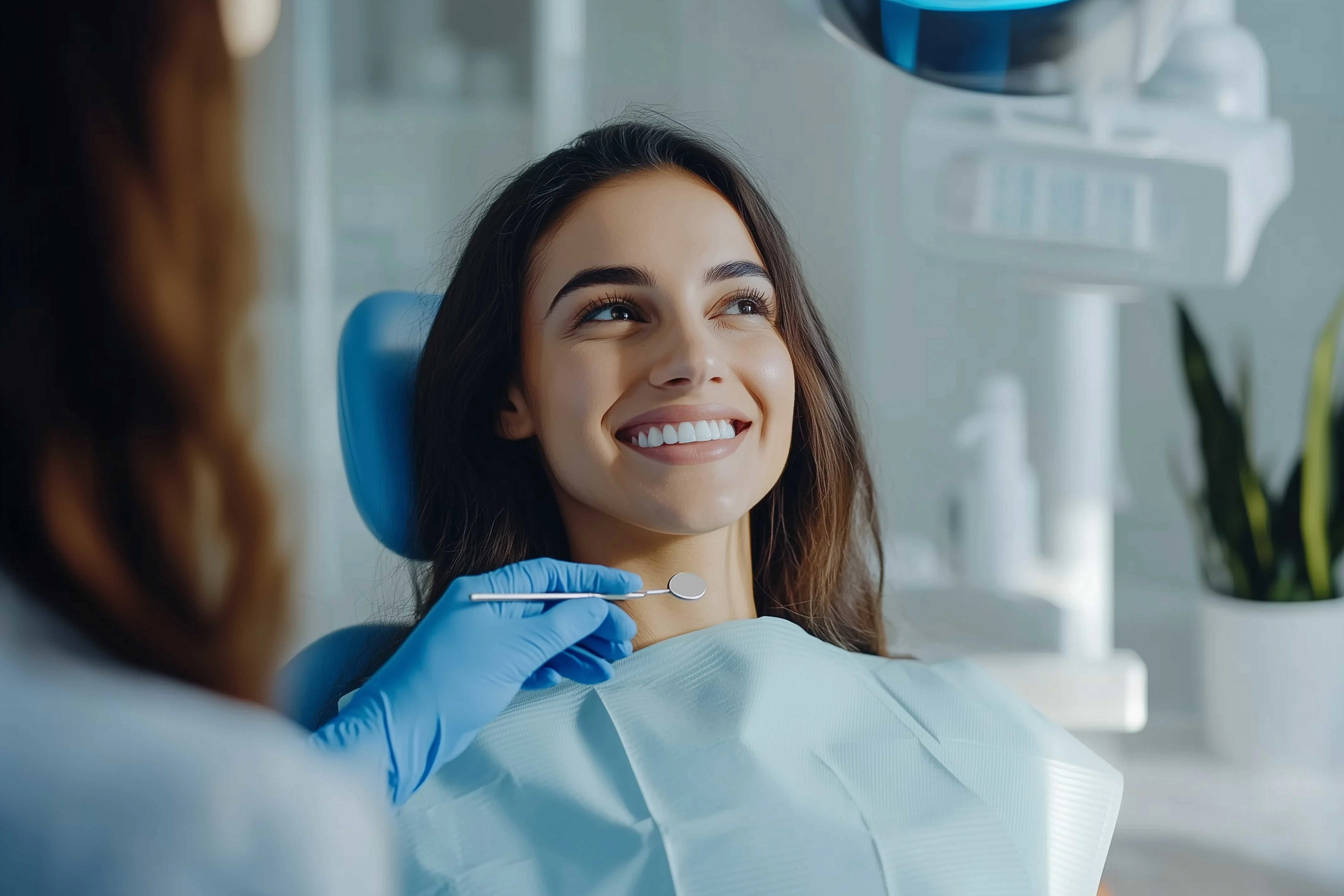 Nainen hymyilee, kun hän on menossa hampaidensa puhdistukseen 