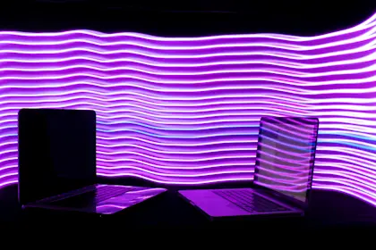 two laptops surrounded by neon lights