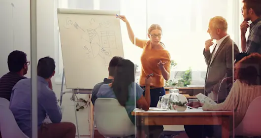 Woman pointing at board.