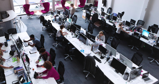 People working in large open space office 