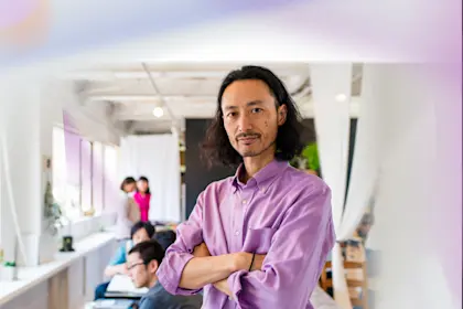 Portrait of a businessman stood in his office with his arms crossed, looking at the camera