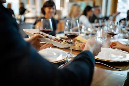 Close up of a man eating tapas and drinking wine