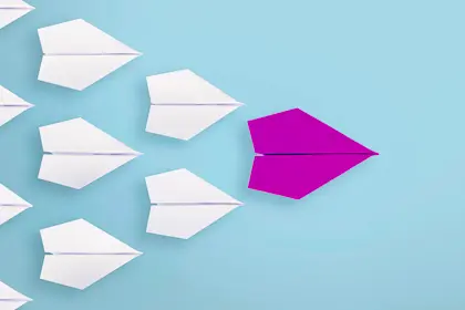 Several paper airplanes following the leader plane