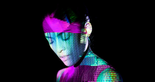 Woman with colorful light reflections of abstract shapes across her face