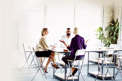 Female business owner leading project meeting with employees in design studio conference room